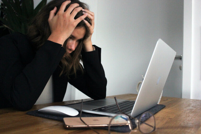 Image of a frustrated woman sitting infront of a laptio